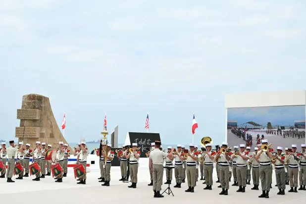 فرقة عسكرية فرنسية تعزف خلال الحفل التذكاري الدولي على شاطئ أوماها بمناسبة الذكرى الثمانين لإنزال الحلفاء «D-Day» في النورماندي أثناء الحرب العالمية الثانية بسان لوران سور مير شمال غربي فرنسا 6 يونيو 2024 (أ.ف.ب)
