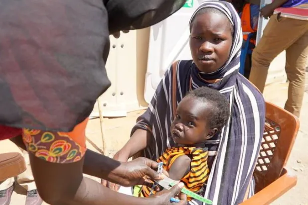 Yetersiz beslenme sorunu yaşayan Sudanlı bir çocuğun muayenesi (Dünya Gıda Programı)