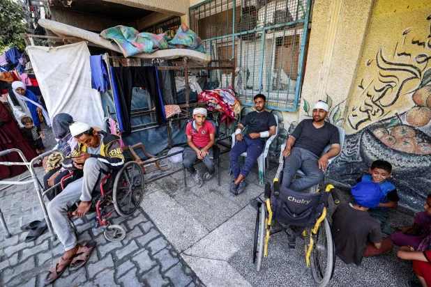 عائلة نازحة في ملجأ بمدرسة تديرها وكالة الأمم المتحدة لإغاثة وتشغيل اللاجئين الفلسطينيين في مخيم النصيرات وسط قطاع غزة في 7 يونيو (أ.ف.ب)