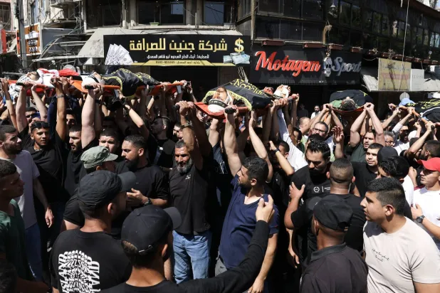 مشيّعون يحملون جثث الفلسطينيين الذين قُتلوا في أعقاب غارة إسرائيلية خلال جنازتهم بقرية كفردان بالقرب من مدينة جنين بالضفة الغربية (إ.ب.أ)