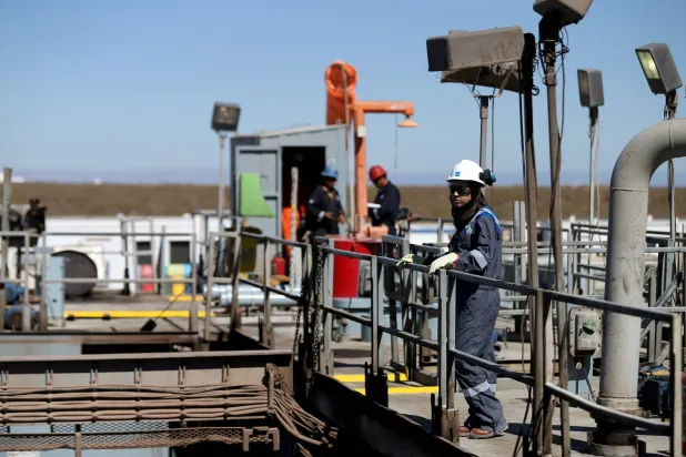 عمال في موقع حفر نفطي في حقل فاكا مويرتا غرب الأرجنتين (رويترز)