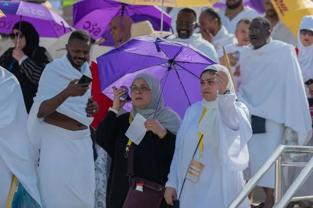 عدد من الحجاج يستخدمون هواتفهم للتواصل مع ذويهم في دول أخرى (موقع إس تي سي)