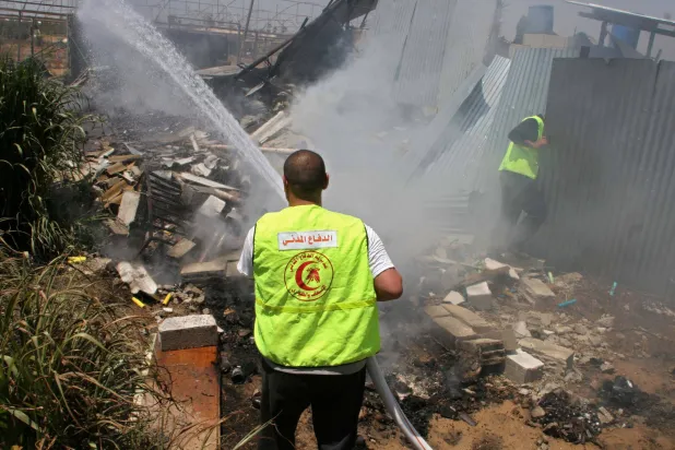 رجل إطفاء فلسطيني يحاول إخماد حريق في مسبك معادن في رفح (أرشيفية - رويترز)