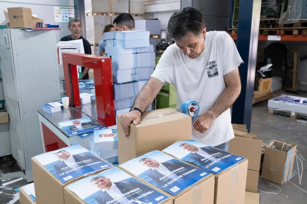 موظف في إحدى المطابع يتحقق من ملصقات ومنشورات الحملة المطبوعة للانتخابات البرلمانية الفرنسية المقبلة (أ.ف.ب)