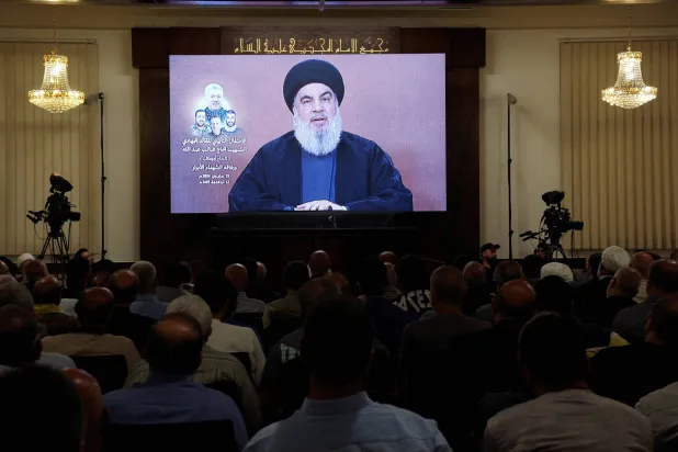 زعيم «حزب الله» اللبناني حسن نصر الله خلال خطاب متلفز في حفل تأبين طالب عبد الله، القائد الميداني الكبير في المجموعة التي قُتل فيها في 11 يونيو إلى جانب ثلاثة مقاتلين آخرين من حزب الله في غارة إسرائيلية على قرية جويا في جنوب لبنان... الصورة في الضاحية الجنوبية لبيروت، لبنان، 19 يونيو 2024 (رويترز)