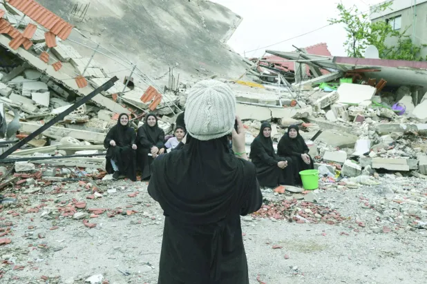 
لبنانيات يلتقطن صورة إلى جانب منزل مدمَّر بغارة إسرائيلية في بلدة عيتا الشعب بالجنوب (أ.ف.ب)