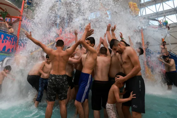 عراقيون هاربون من انقطاع الكهرباء في منازلهم إلى المسابح الخاصة (رويترز)