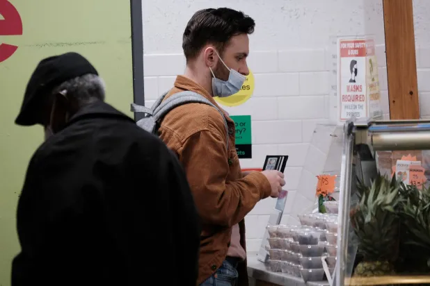 شخصان يرتديان الكمامات الطبية في متجر بمدينة فيلادلفيا بولاية بنسلفانيا الأميركية 15 أبريل 2024 (أ.ف.ب)