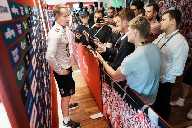 كاسبر يولماند مدرب الدنمارك محاصر بالإعلاميين قبل مواجهة ألمانيا (أ.ف.ب)