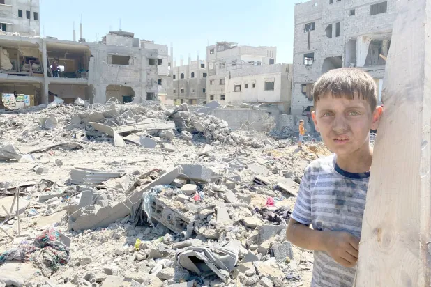 
طفل فلسطيني أمام مبان مدمرة بفعل غارات جوية إسرائيلية في حي الصبرة وسط مدينة غزة أمس (د.ب.أ)