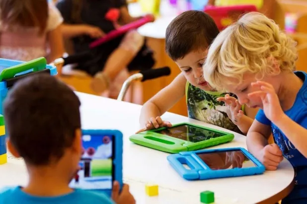 الخبراء يؤكدون إنه عندما يرى الطفل والديه يقضيان الوقت أمام الشاشات فمن المرجح أن يقلد هذا السلوك (أرشيفية- رويترز)