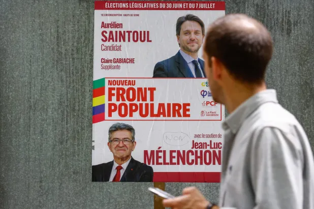 ملصقات دعائية للمرشحين في الانتخابات النيابية الفرنسية قرب باريس (إ.ب.أ)