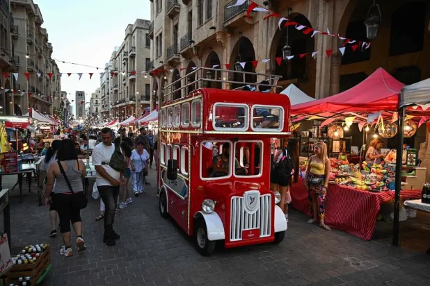  A vehicle dressed like a double decker bus drives near revelers during the Beirut Street Festival in downtown Beirut on June 22, 2024. (AFP)