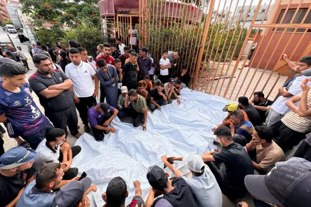 مشيعون بجوار جثث الفلسطينيين من عائلة زعرب الذين قتلوا في غارة إسرائيلية بمستشفى ناصر في خان يونس، جنوب قطاع غزة (رويترز)