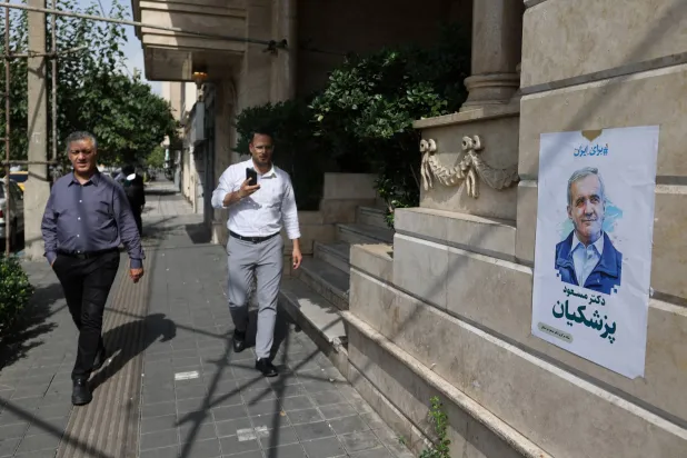 ملصق للمرشح الإصلاحي مسعود بزشكيان معروض في أحد شوارع طهران (رويترز)