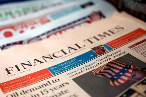 غلاف صحيفة «فاينانشيال تايمز» يظهر مع صحف أخرى في كشك لبيع الصحف في نيويورك (رويترز)