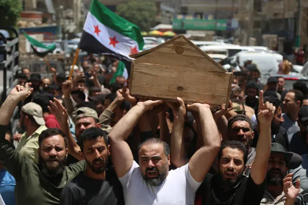 أشخاص يحملون نعش «أبو مالك» الذي قُتل بأعمال شغب خلال الاحتجاجات ضد تركيا أثناء جنازة بمدينة عفرين بريف حلب في سوريا يوم 2 يوليو 2024 (إ.ب.أ)