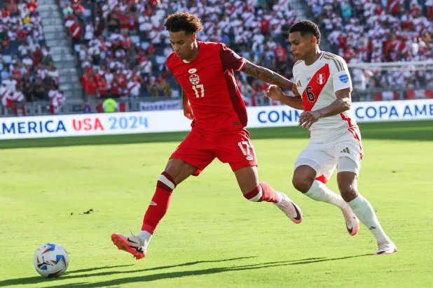 تاجون بوكانان يقود هجمة لمنتخب كندا خلال المواجهة أمام منتخب بيرو (أ.ب)