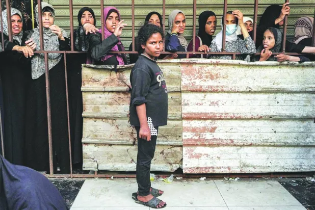 Gazze Şeridi'nin orta kesimindeki Deyr el-Balah'ta ekmek kuyruğuna giren Filistinli kadınlar (AFP)