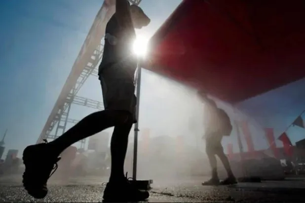 رجل يمشي في ظل طقس تتخلله نسبة عالية من الرطوبة (رويترز)