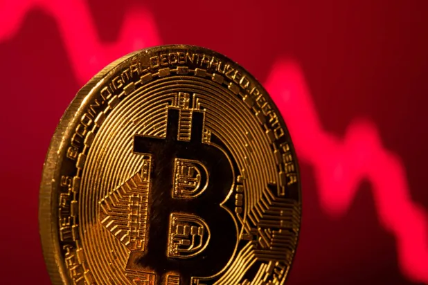 العملة الرقمية «بتكوين» أمام رسم بياني للأسهم (رويترز)