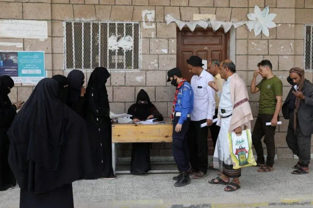 Beneficiaries of the World Food Program gather outside a food distribution center in Sanaa before the program’s activities were halted (Reuters)
