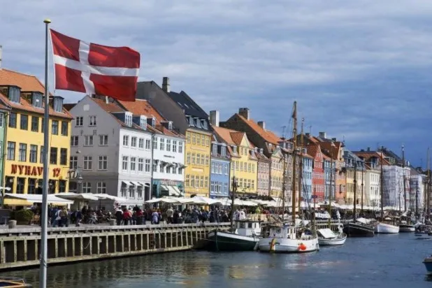 قوارب راسية في منطقة نيهافن في كوبنهاغن أمام عقارات سكنية وتجارية (رويترز)