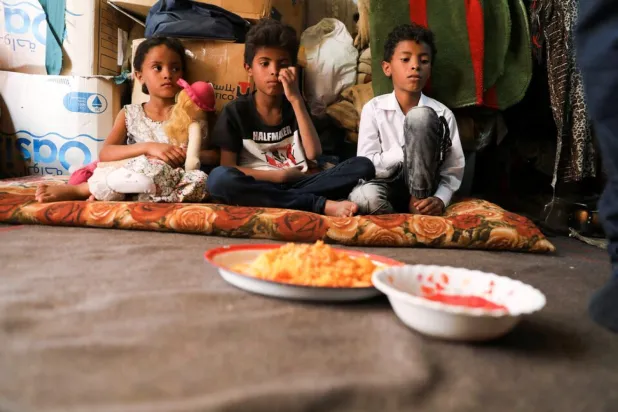 Children wait for lunch at their hut in Sanaa, Yemen August 29, 2022 (Reuters)