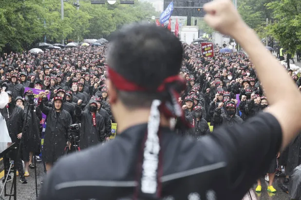 أعضاء النقابة الوطنية لعمال «سامسونغ» يرفعون شعارات خلال مظاهرة خارج مجمع هواسونغ التابع للشركة (أ.ب)