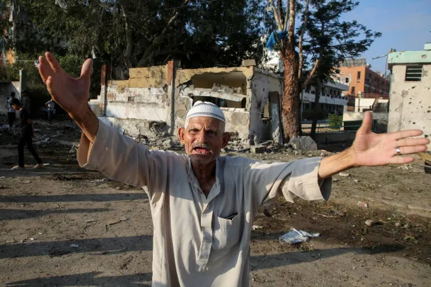 رد فعل رجل فلسطيني إثر غارة إسرائيلية خارج مدرسة تؤوي نازحين في خان يونس (رويترز)