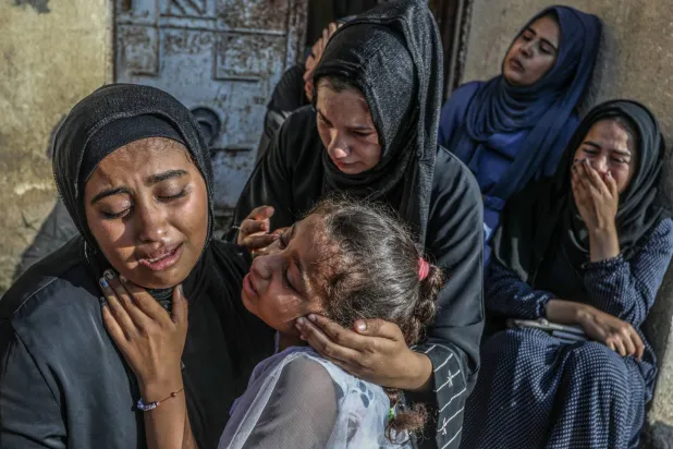 فلسطينيات يبكين فقدان أقارب لهن قضوا بغارة إسرائيلية على مدرسة العودة في شرق خان يونس بجنوب قطاع غزة (أمس)