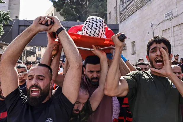 The body of 13-year-old Ghassan Gharib is carried on shoulders after he was shot dead by Israeli forces near Ramallah this July (AFP)