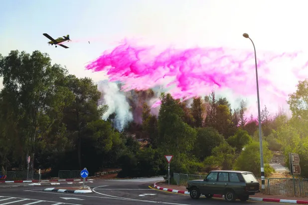 An Israeli firefighter aircraft drops flame retardant on fires smoke after rockets fired from southern Lebanon hit an area in the Upper Galilee region in northern Israel on July 4, 2024. (Photo by JACK GUEZ / AFP)