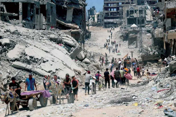  نازحون وسط الدمار في حي الشجاعية شرق مدينة غزة أمس (أ.ف.ب)