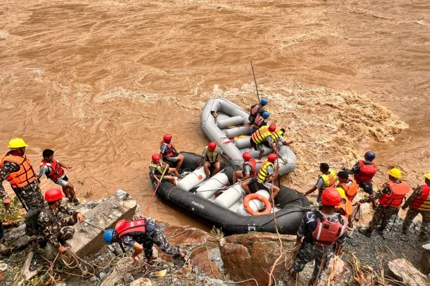 عمال إنقاذ يبحثون في المياه العكرة بمنطقة الحادث (د.ب.أ)
