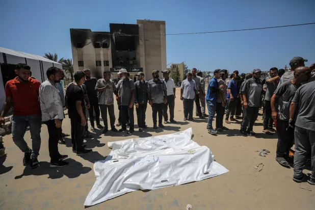 جثث ضحايا الضربة الإسرائيلية على المواصي قرب خان يونس السبت (إ.ب.أ)