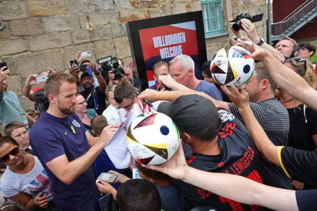 كين يوقع للمعجبين في أثناء مغادرته المركز الإعلامي في معسكر الفريق بـ«منتجع فايمارر لاند للغولف» (أ.ف.ب)