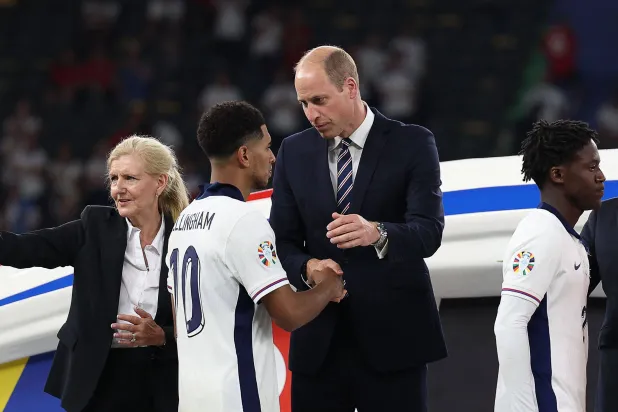 ويليام أمير ويلز يصافح بيلينغهام لاعب إنجلترا خلال تتويجهم بالميداليات الفضية (أ.ف.ب)