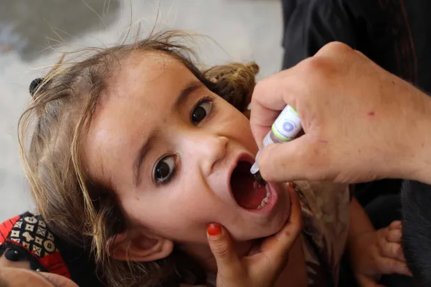 عامل صحي يقوم بتطعيم طفل ضد شلل الأطفال في قندهار (إ.ب.أ)