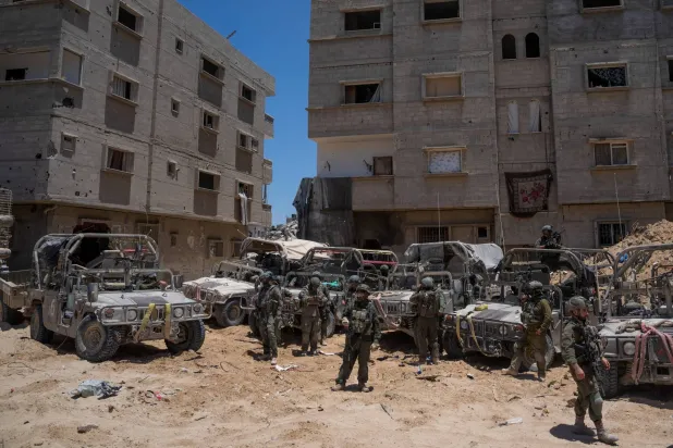 جنود إسرائيليون بجوار مركبات عسكرية في رفح جنوب قطاع غزة الشهر الحالي (رويترز)