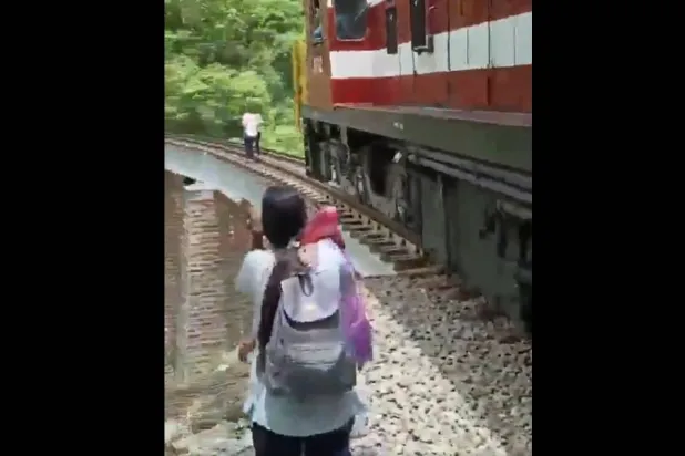 صورة مثبتة من الفيديو الذي يظهر القطار يقترب من الزوجين المندمجين بالتصوير