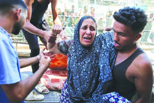 İsrail'in dün Gazze Şeridi'nin güneyindeki Han Yunus'a düzenlediği saldırıda yaralanan Filistinli bir kadın Nasır Hastanesi'ne kaldırılırken (Reuters)