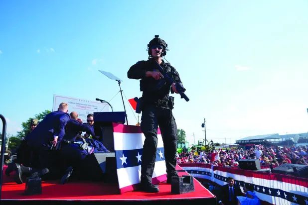 عملاء «الخدمة السرية» يعتلون خشبة المسرح بعد محاولة اغتيال دونالد ترمب في بتلر بولاية بنسلفانيا مساء السبت (أ.ب)