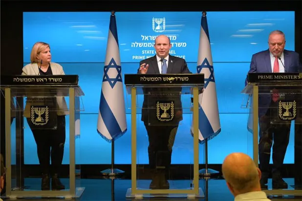 نفتالي بنيت خلال ترؤسه الحكومة الإسرائيلية يتحدث محاطاً بالوزيرين حينها أفيغدور ليبرمان وأورنا باربيفاي (الحكومة الإسرائيلية)