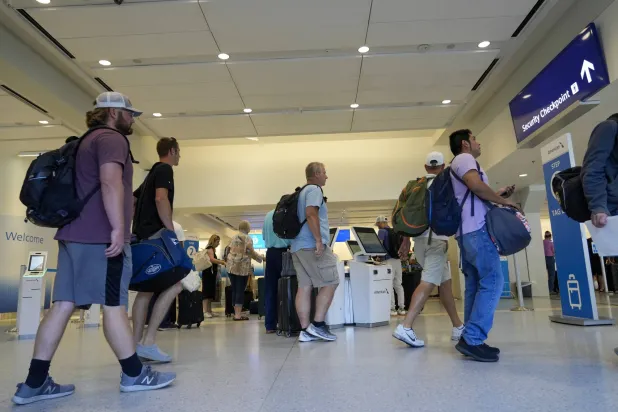 مسافرون في مطار «دالاس فورت وورث الدولي» في تكساس (أ.ب)