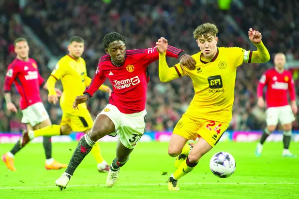 أربلاستر لاعب شيفيلد يونايتد (يمين) في صراع على الكرة مع ماينو لاعب مانشستر يونايتد (إ.ب.أ)