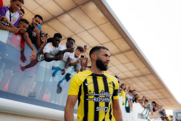 بنزيمة وخلفه مشجعون يلتقطون الصور بهواتفهم (نادي الاتحاد)