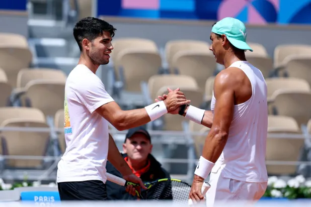 كارلوس ألكاراس يصافح نادال أثناء التدريب (رويترز)