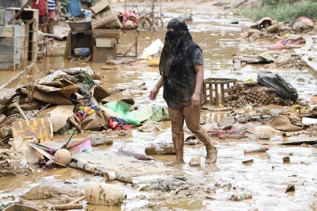 سيدة تعبر ركاماً تسبب به الإعصار «غايمي» في قرية بالفلبين (أ.ف.ب)