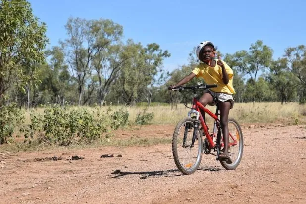 طفلة تضع الخوذة أثناء ركوبها الدراجة (رويترز)